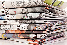 Stapel Zeitungen symbolisiert die Dämm-Kritik und die Dämm-Vorurteile in den Medien.